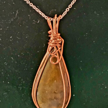 Petrified wood pendant wrapped in copper wire