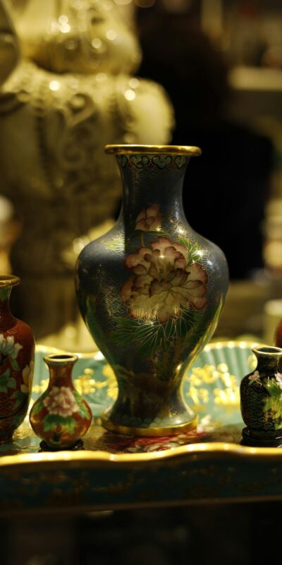 Close-up of intricately designed ornamental vases with floral patterns in warm lighting.